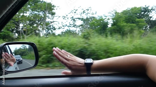 Hand of a woman playing at the car window 