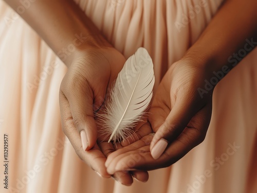 Graceful Aesthetic Concept. A delicate white feather cradled in two hands, symbolizing purity and gentleness against a soft, muted background.