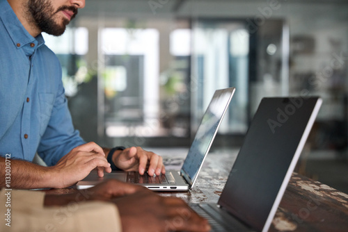 Professional business people, two male employees workers using computers technology working in office. Busy diverse business men team typing on laptop sitting at work desk. Close up photo. photo