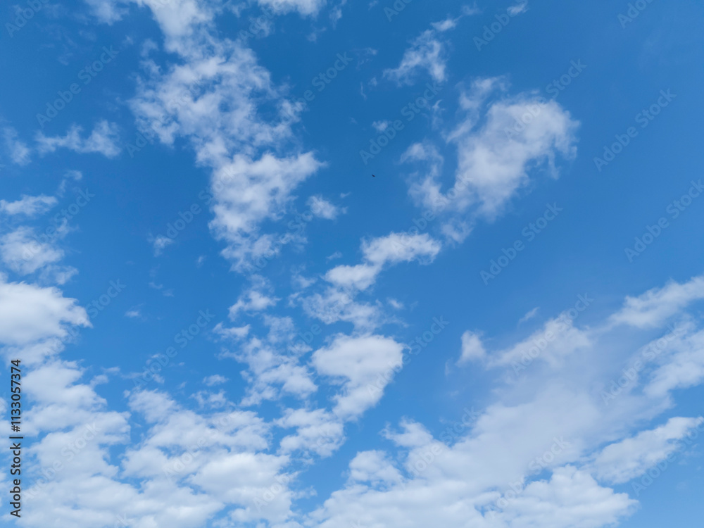 Obraz premium Bright blue sky filled with white fluffy clouds, perfect for inspiration and relaxation.
