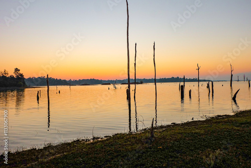 Gorgeous sunrise, orange, blue and red sky over the reservoir horizon in Laos 