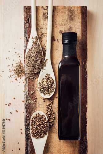 Bottle of seed oil and seeds of coriander, hemp, cumin.