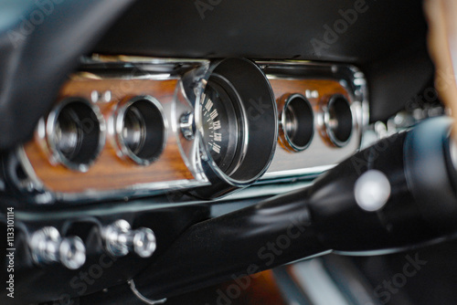 Close-Up View of Vintage Car Dashboard With Wood Paneling and Chrome Details