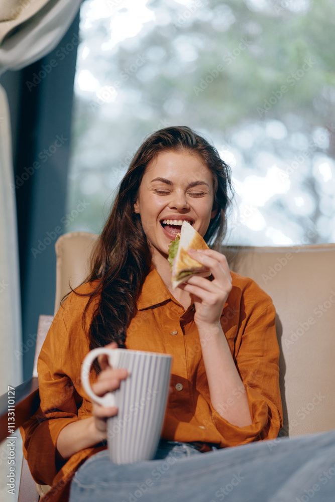 Joyful young woman enjoying a healthy sandwich and coffee in a cozy indoor setting, wearing an orange shirt, with a cheerful expression and natural light Joyful young woman enjoying a healthy sandwich and coffee in a cozy indoor setting, wearing an orange shirt, with a cheerful expression and natural light