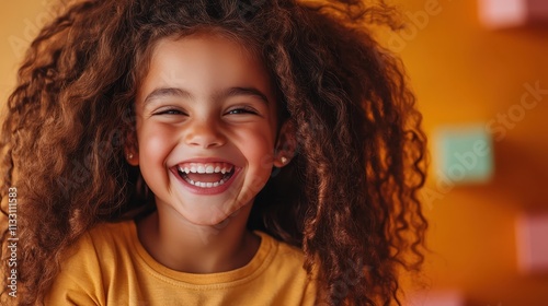 A radiant girl with voluminous curly hair beams with joy, set against a vibrant orange backdrop, expressing happiness, youthfulness, and boundless energy. photo