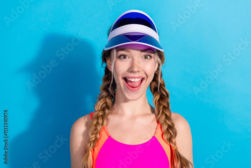 Foto Joyful young sportswoman in vibrant activewear against a striking blue background