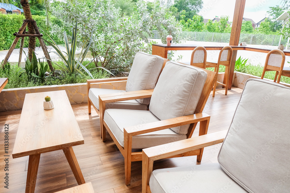 Fototapeta premium Wicker chair and wooden table in restaurant,Rattan chair in scandinavian interior of living room,Mediterranean minimal wall and green plant exterior architecturer,warm beige tones,copy space.