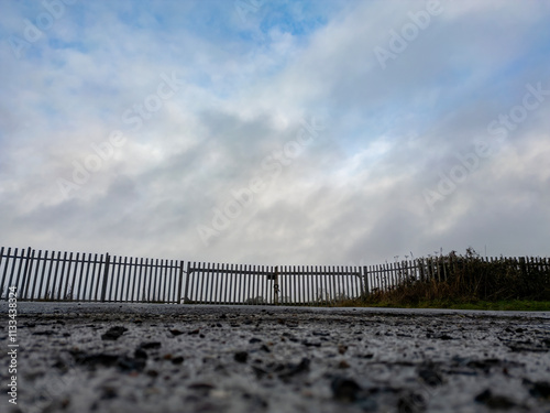 A low angle view of a section of metal fence surrounding an industrial estate in Derbyshire, UK