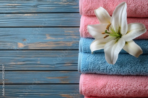 Soft towels and white lilies create a serene spa atmosphere in calming colors
