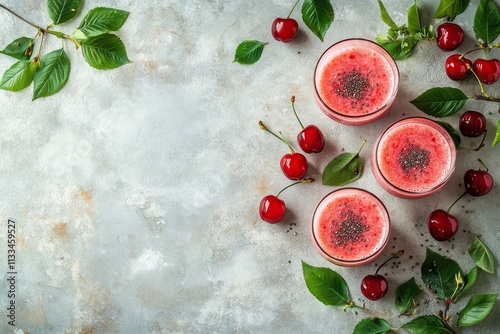 Refreshing cherry smoothies with seeds and green leaves on a light background