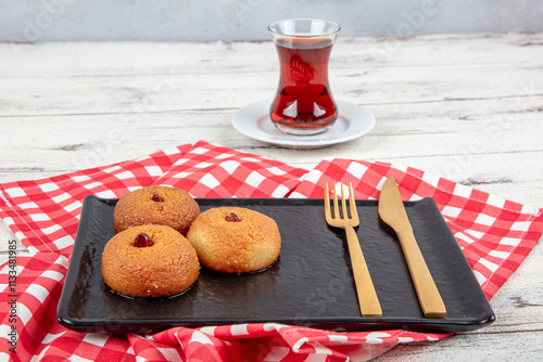 Sekerpare dessert. Ramadan dessert. Sekerpare dessert with syrup and Turkish tea on a serving plate. photo