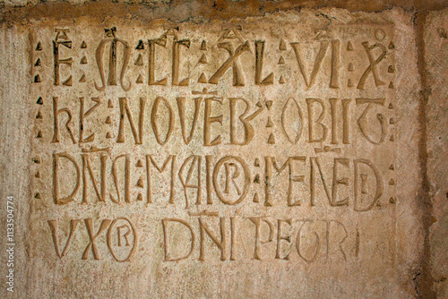a close-up of an ancient stone inscription with intricate lettering, likely Latin, providing a glimpse into the rich history and cultural heritage of the site