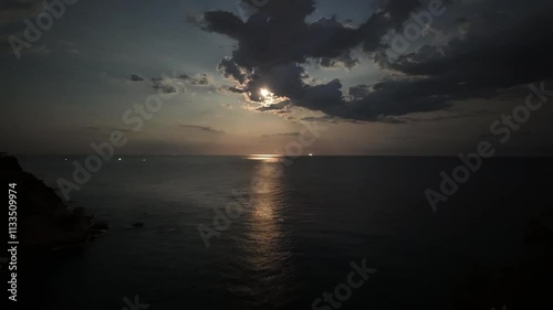 Timelapse with moonlight reflected on the sea at night with clouds, 4K horizontal background