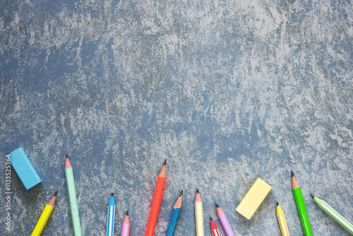 Pencils and erasers on textured gray background