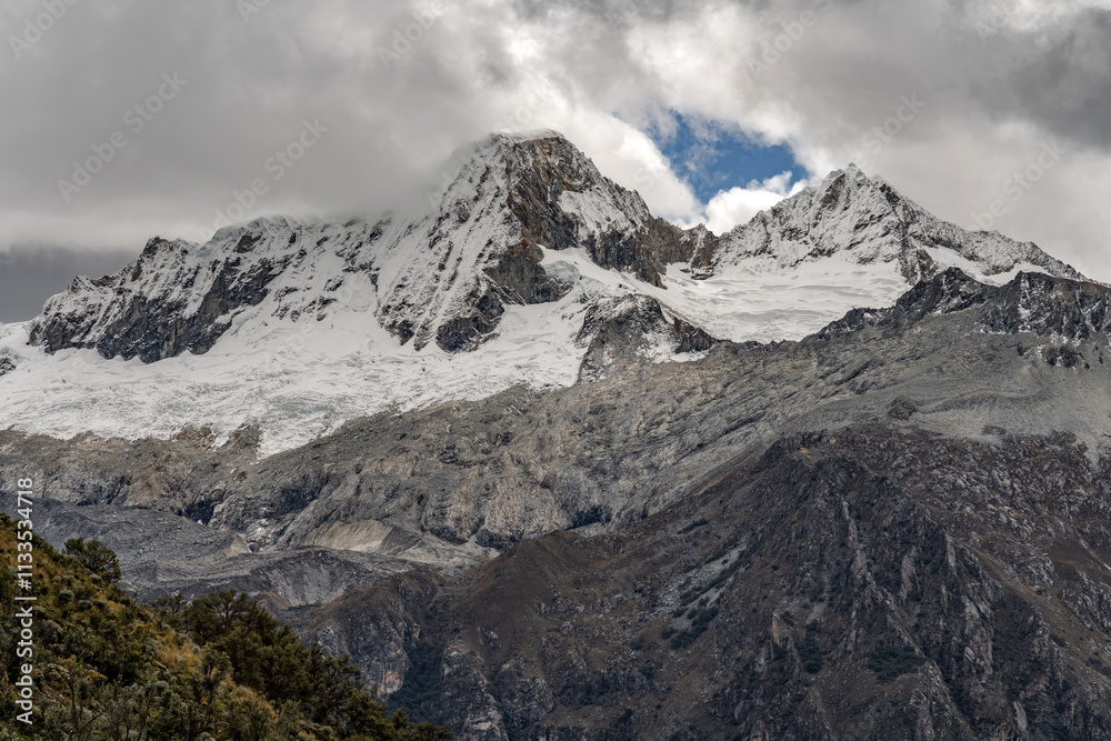 Fototapeta premium Breathtaking winter landscape featuring snow-covered mountains under a beautiful misty sky.