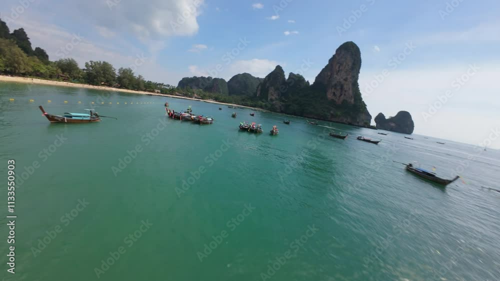 This aerial photograph showcases vibrant longtail boats moored in Krabis clear turquoise waters, highlighting the natural beauty and scenic landscapes of this tropical paradise. FPV drone.