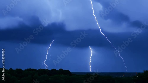 Dramatic night sky with multiple lightning strikes illuminating dark clouds over a silhouetted horizon.