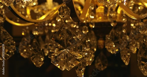 A sparkling golden crystal chandelier hangs elegantly from the ceiling.