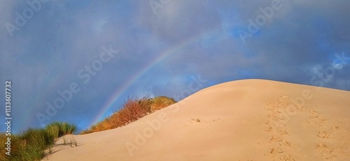 Düne unter Regenbogen und Wolken photo