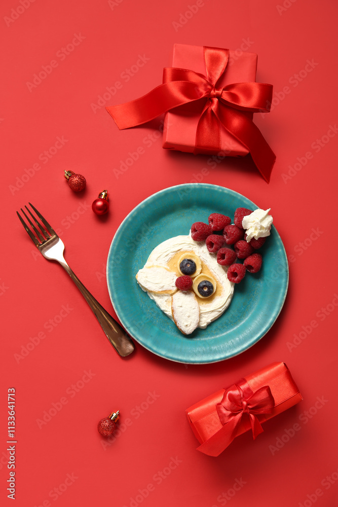 Plate with pancake in shape of Santa on red background. Christmas celebration Plate with pancake in shape of Santa on red background. Christmas celebration