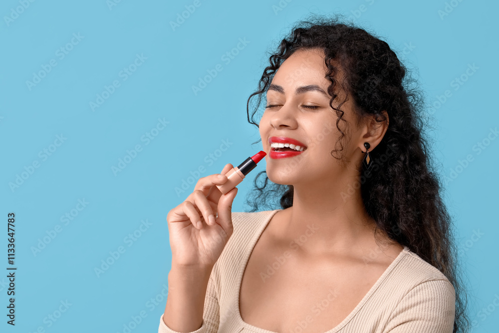 Happy young African-American woman with red lipstick on blue background Happy young African-American woman with red lipstick on blue background
