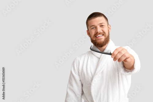 Happy young man in bathrobe...