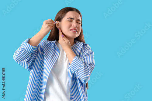Young woman using ear drops...