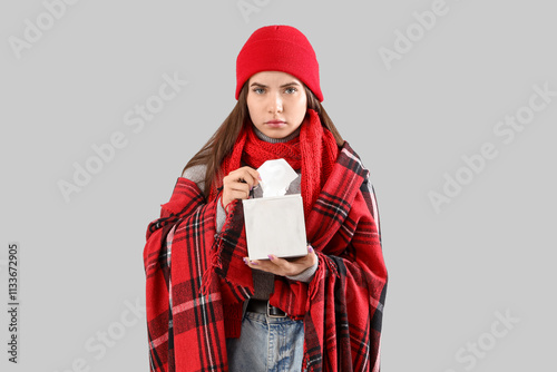 Ill young woman with tissue...