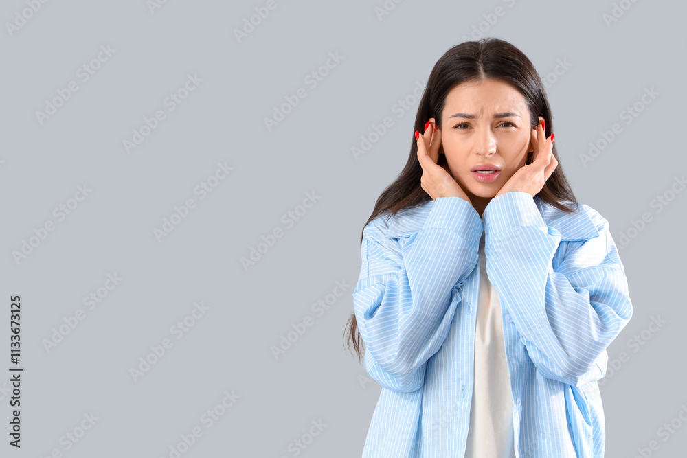 Young woman with otitis on grey background Young woman with otitis on grey background