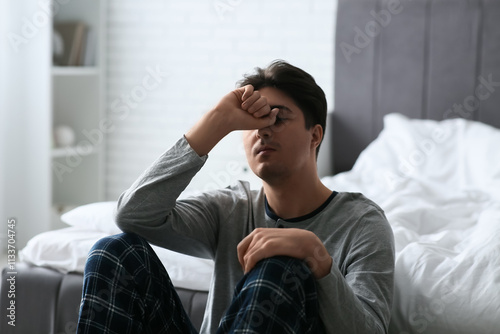 Depressed young man in bedroom