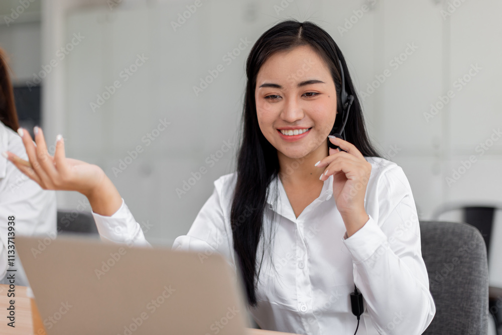 Smiling friendly asian female call-center agent with headset working on support call center agent hotline in the office Smiling friendly asian female call-center agent with headset working on support call center agent hotline in the office