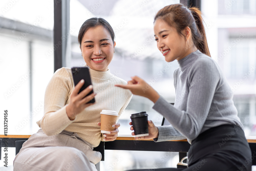 Two asian Female friends drinking coffee and using mobile phones while sitting at cafe
Two asian Female friends drinking coffee and using mobile phones while sitting at cafe
