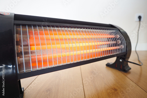 Modern electric infrared heater in living room, closeup