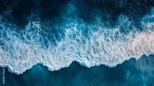 Powerful ocean waves crashing on the shore, seen from above.