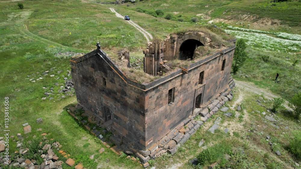 Tilt up aerial shot of Saint Paul and Peter (Surb Pogos Petros) Church on a sunny day.  Aparan Reservoir, Armenia.