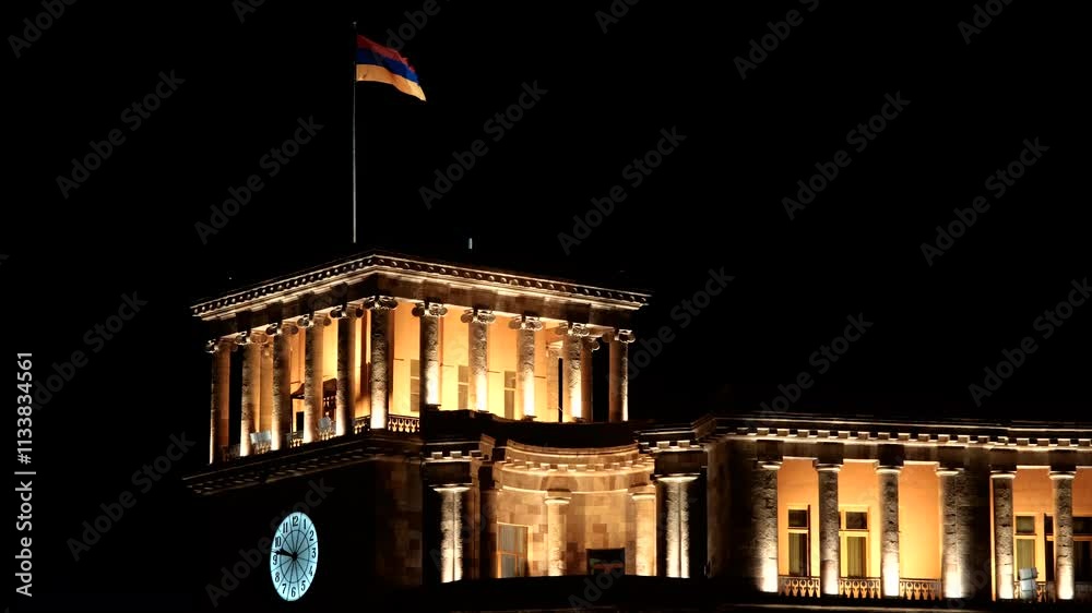 Tripod shot of Armenian National flag waiving on the Clock Tower of Government building at night. Yerevan, Armenia.