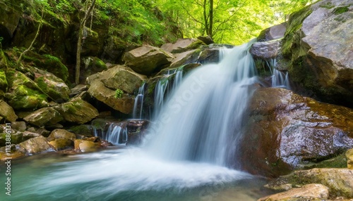 Crystal Clear Waterfall Cascading Over Jagged Rocks in Hidden Forest Valley