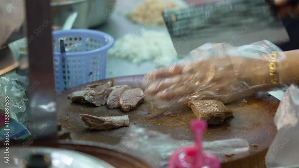 Close-up of female hands in polyethylene gloves cutting duck meat. Popular Street Food at Chinatown Night Market. Bangkok, Thailand Close-up of female hands in polyethylene gloves cutting duck meat. Popular Street Food at Chinatown Night Market. Bangkok, Thailand