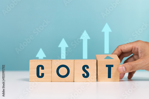 Cost, lean or cost reduction, expense, interest rates and dividends. Hand hold wooden block with the word cost and arrow up for increase of business profits