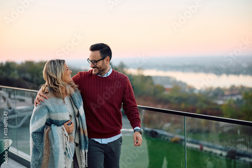 Happy couple talking while enjoying on their terrace during autumn day. photo