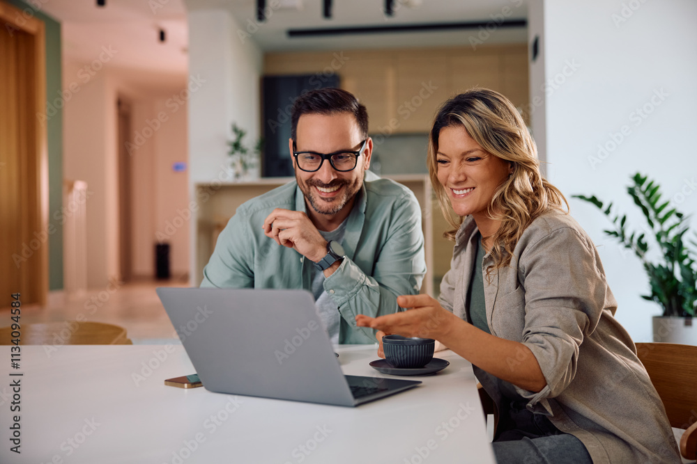 Happy couple using laptop while drinking coffee at home. Happy couple using laptop while drinking coffee at home.