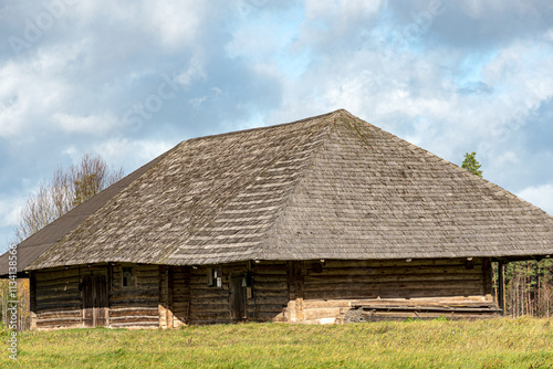 beautiful landscape with an old wooden building, autumn day, sky full of clouds