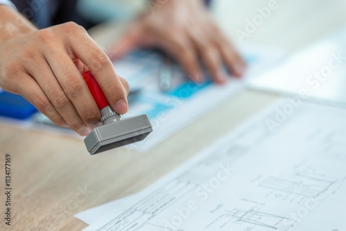 Photos A person stamping a document with a rubber stamp.