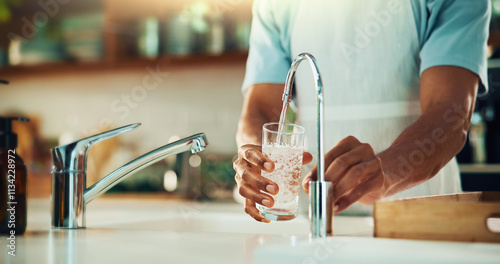 Person, tap and hands with glass of water in kitchen for fresh drink, liquid and hydration. Sink closeup, thirsty or pouring pure beverage in container for nutrition, drinking or filtration in home photo