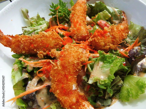 Crispy shrimp salad topped with salad sauce.