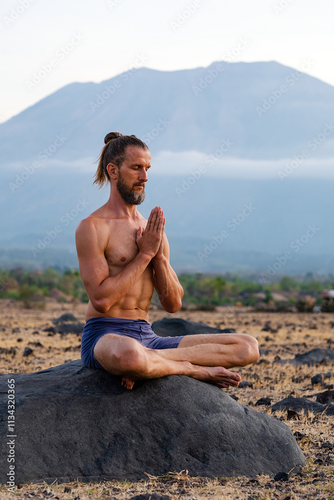 Man Practicing Yoga Meditation Outdoors in Nature with Mountain View. Man Practicing Yoga Meditation Outdoors in Nature with Mountain View.
