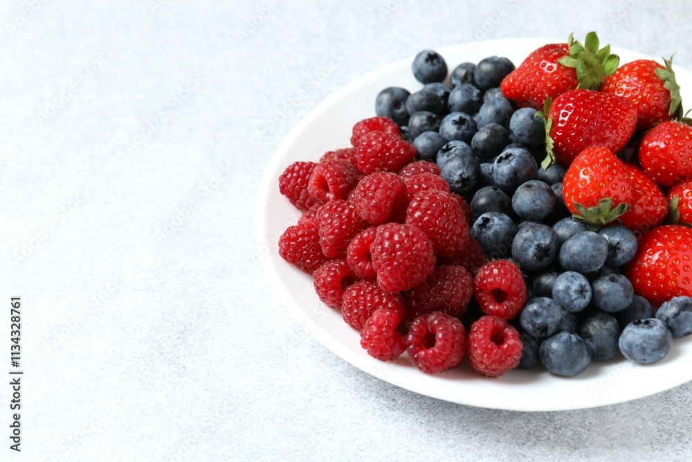 Different fresh ripe berries in bowl on the table Different fresh ripe berries in bowl on the table