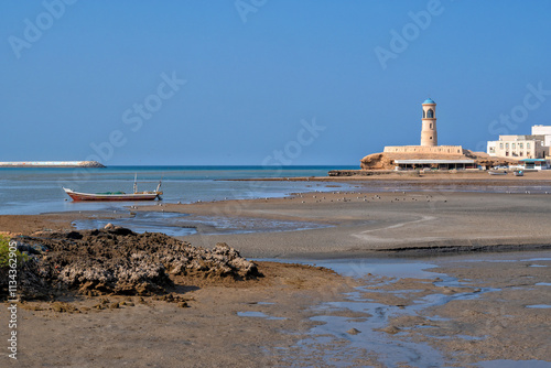 Sur, Oman. Ash Sharqiyah Oman Sultanat Moyen Orient. Lighthouse and fishing boats in the port. Traditional Arab city	 photo