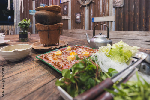 Thai hot pot food call Jim Jum with pork soup sauce and vegetable ingredient on table in Thailand photo