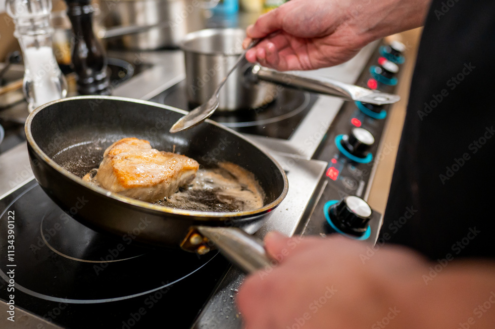 A chef skillfully flips a piece of meat in a frying pan on a modern stove, with steam rising and pots in the background, showcasing a dynamic cooking scene. A chef skillfully flips a piece of meat in a frying pan on a modern stove, with steam rising and pots in the background, showcasing a dynamic cooking scene.